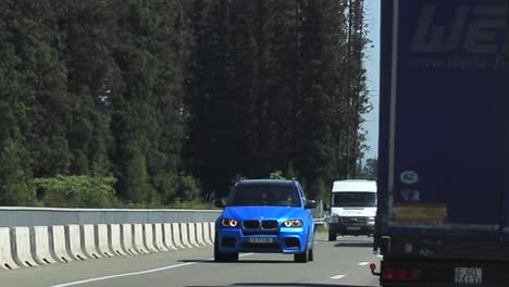 vehicles driving on a tree-lined highway