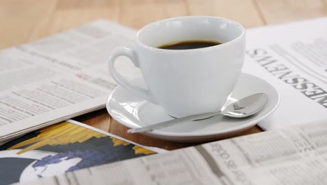 jornal e café preto na mesa