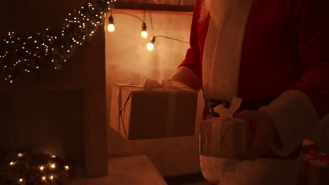 close - up of santas hand: brings gifts under the christmas tree for children. give gifts to children on christmas night. santa puts a gift under the christmas tree. high quality 4k footage