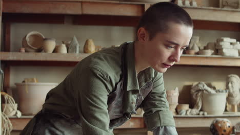 woman using laptop in pottery workshop