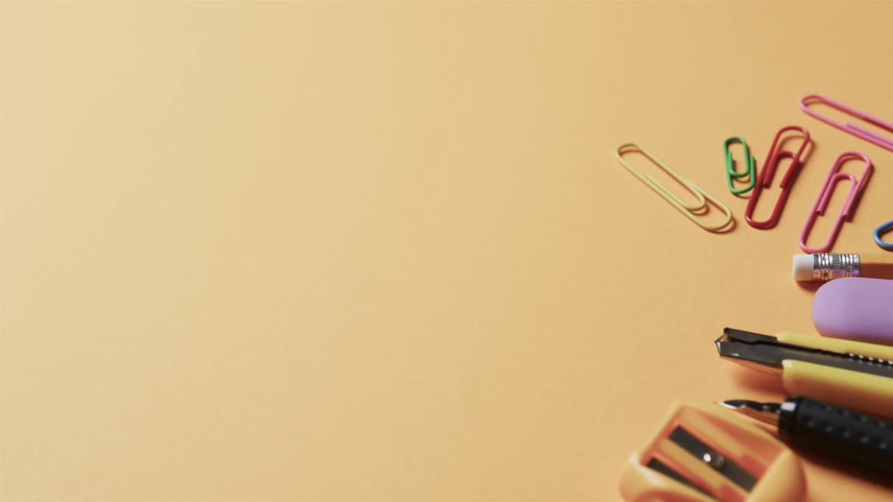 슬로우 모션으로 베이지색 배경에 복사 공간이 있는 다채로운 학교 서류의 클로즈업