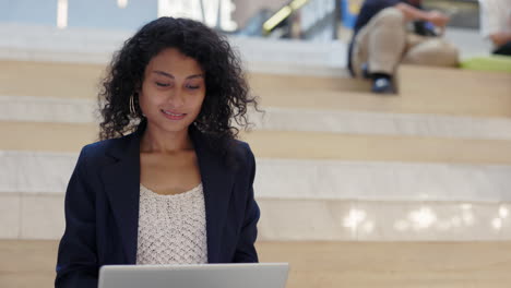 woman working on laptop on stairs in modern office