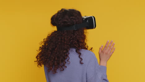 mujer joven usando casco de auriculares de realidad virtual para jugar aplicación de juego de simulación, viendo contenido de video