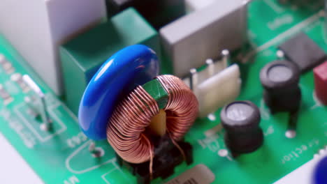 Close-up-footage-of-electronic-parts-on-a-PCB-zoomed-out-revealing-other-parts-and-components