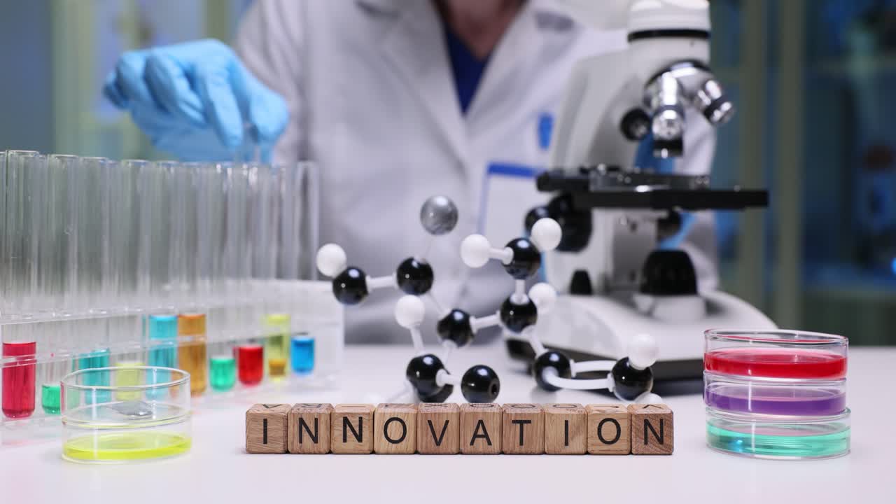Laboratory worker carefully examines liquids inside test tubes