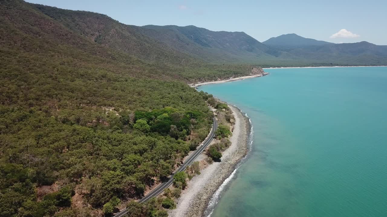 Drone aerial going lower and parallax over tropical blue water and beach