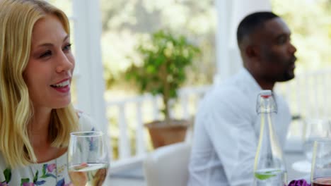 friends interacting with each other while having glass of wine