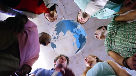 animation of rotating globe over group of diverse business team holding hands