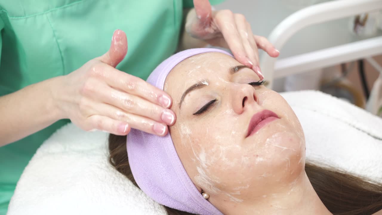Lady Getting Spa Massage. Beautiful young woman during facial massage in cosmetic salon