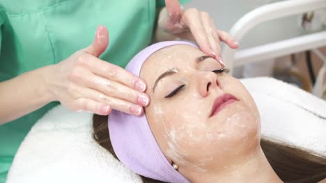 Lady Getting Spa Massage. Beautiful young woman during facial massage in cosmetic salon