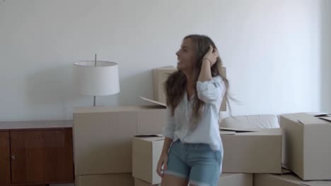 mujer feliz bailando en un apartamento nuevo