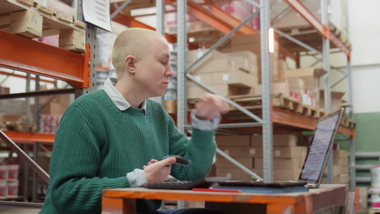 Female Manager Using Scanner and Laptop in Warehouse