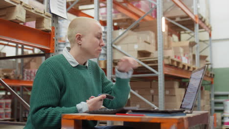 female manager using scanner and laptop in warehouse