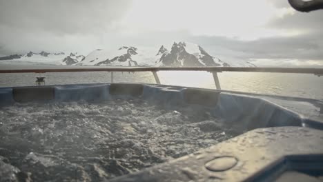 hot tub with bubbles and steam and big snow and ice covered mountains in background