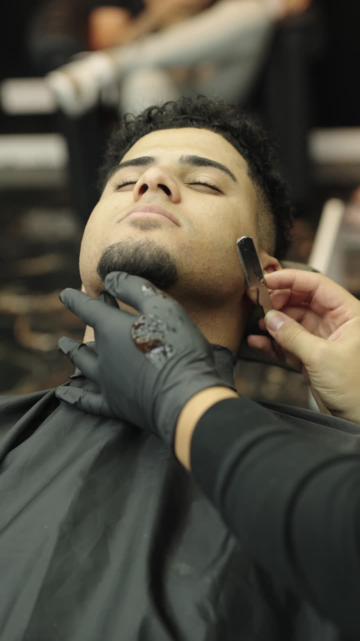 Homem fazendo a barba no barbeiro