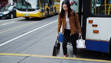 woman getting off a bus in a city