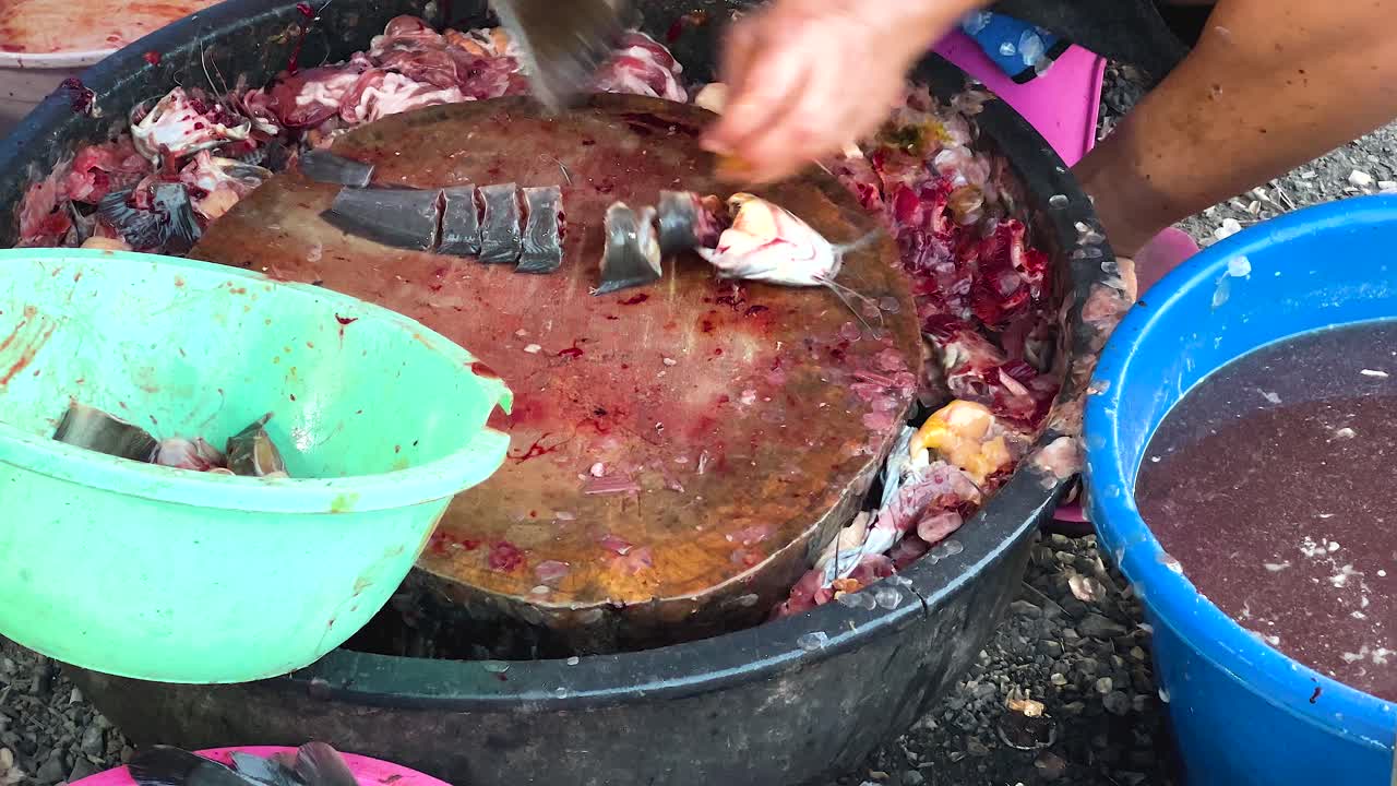 판매자 는 시장 상점 에서 능숙 하게 물고기 를 잘라 낸다