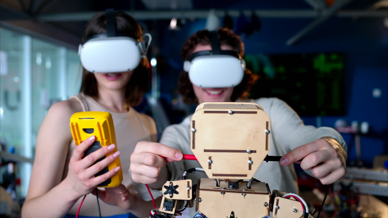 Two young engineers fixing a mechanical robot in the workshop, using VR virtual reality headsets