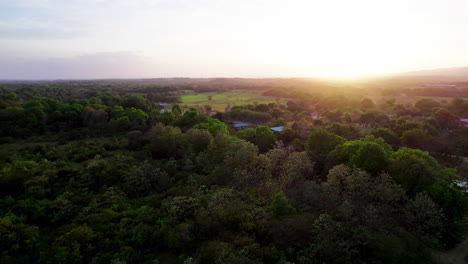 Toma-Aérea-De-La-Ciudad-Rural-De-San-Martin-Con-Grandes-Bosques-Durante-La-Puesta-De-Sol