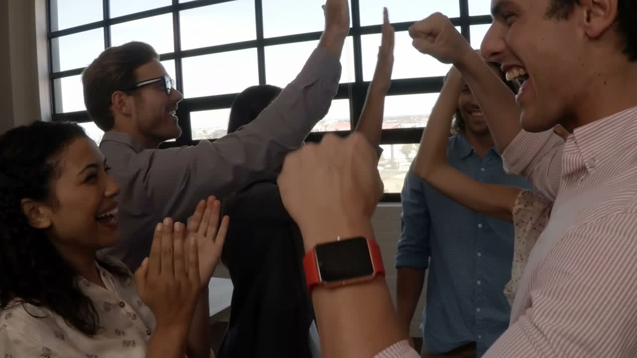 grupo de ejecutivos de negocios que se dan el "high five" el uno al otro