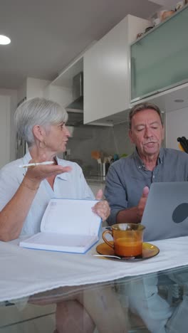 senior couple planning at home with laptop and calendar