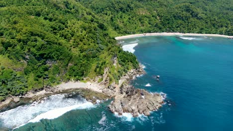 Idyllic-lagoon-and-rocky-cape-on-Wediombo-beach,-Java,-Indonesia,-aerial-view