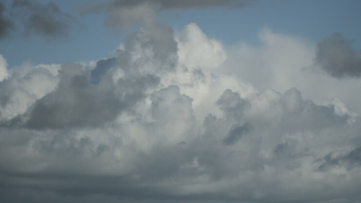 Cumulonimbus clouds developing with darker clouds moving in at the end