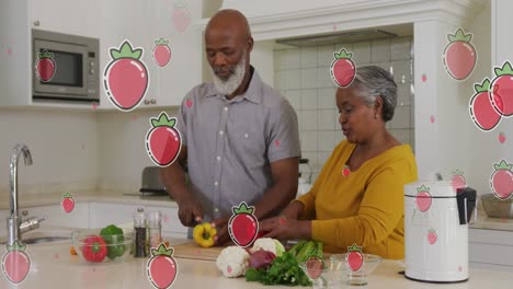 Animation-of-strawberries-over-senior-diverse-couple-preparing-food-at-home