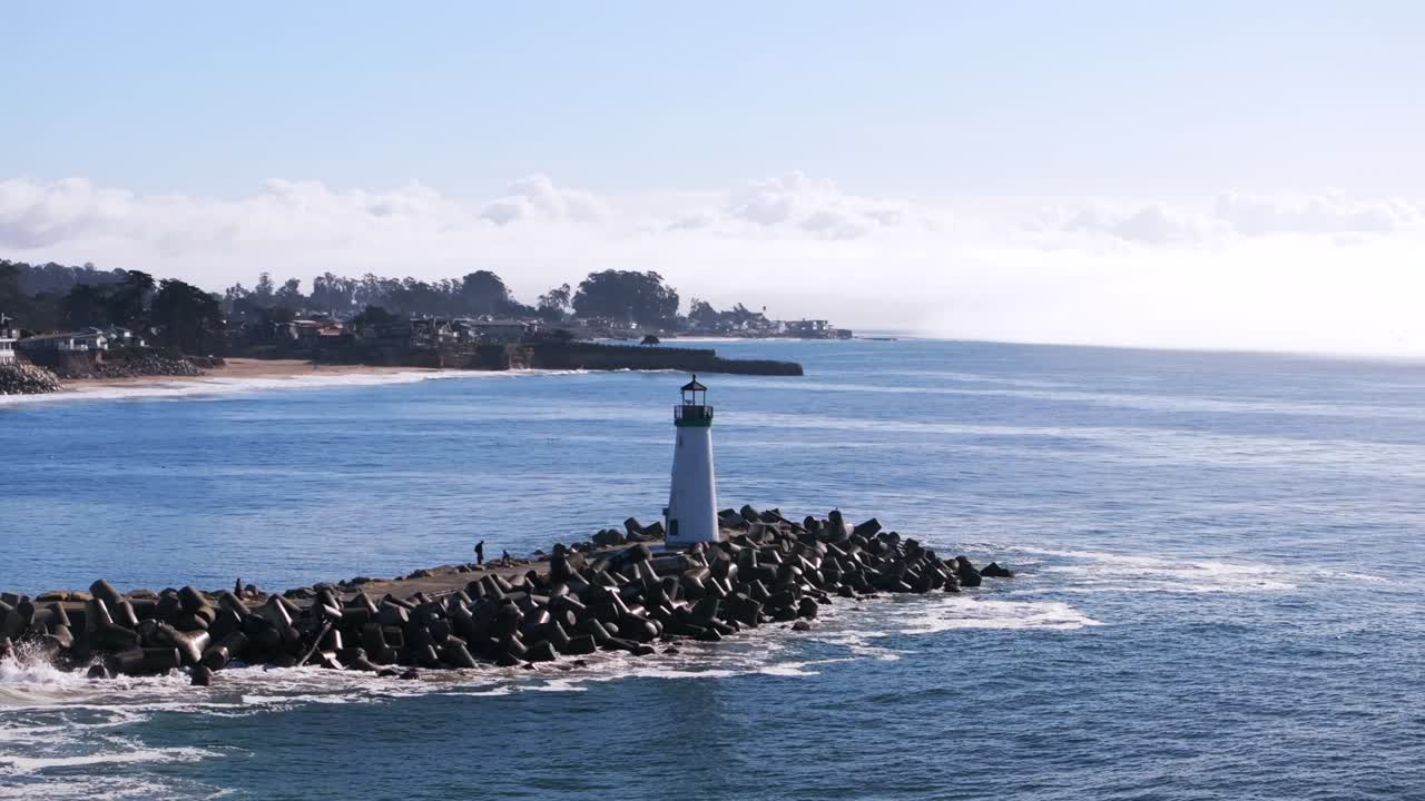 Walton Lighthouse Monterey Bay Santa Cruz California USA aerial drone landscape deep blue Pacific Ocean seagull pelican birds harbor jetty morning blue sky mist fog Pleasure Point forward motion