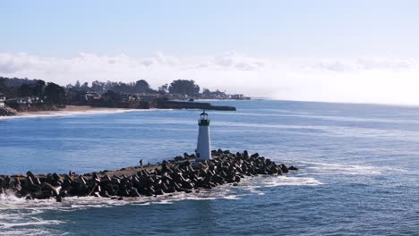walton lighthouse monterey bay santa cruz california usa aerial drone landscape deep blue pacific ocean seagull pelican birds harbor jetty morning blue sky mist fog pleasure point forward motion