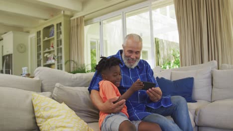 abuelo y nieto usando un teléfono inteligente