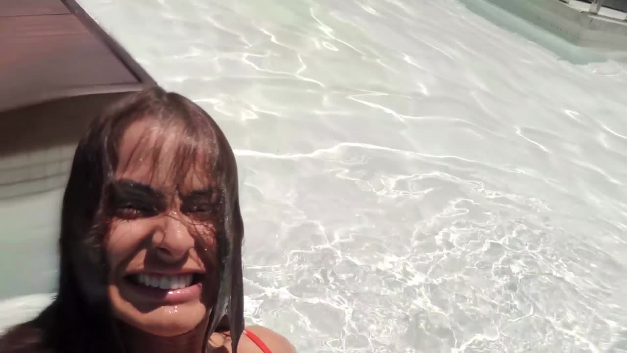mujer sonriente saliendo de la piscina y respirando