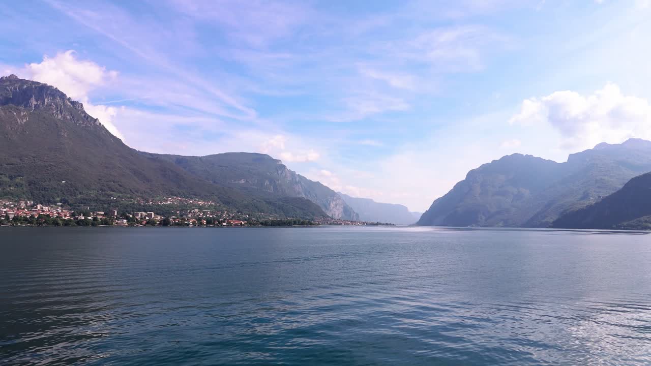 Slow fly over calm Lake Como on a sunny day