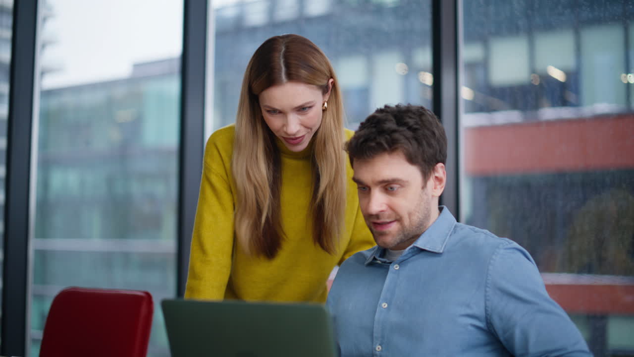 To kolleger har videosamtale på laptop i et kontor nærbilde. Smilende kollegaer