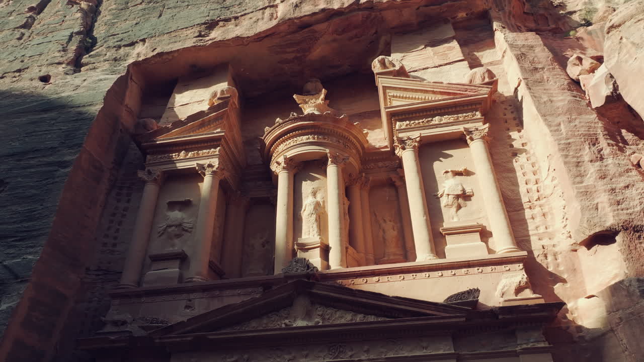 vista de bajo ángulo del tesoro tumbas excavadas en la roca figuras mitológicas esculturas, petra