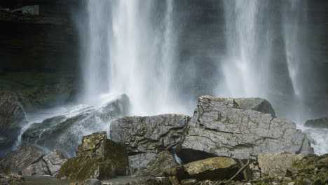 el agua en cascada cae sobre grandes bloques rectangulares de rocas rociando niebla