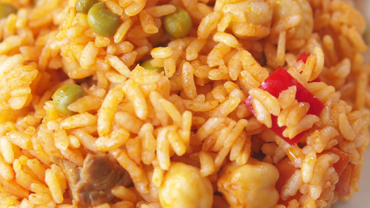 Close-up of a rice dish with peas and red pepper