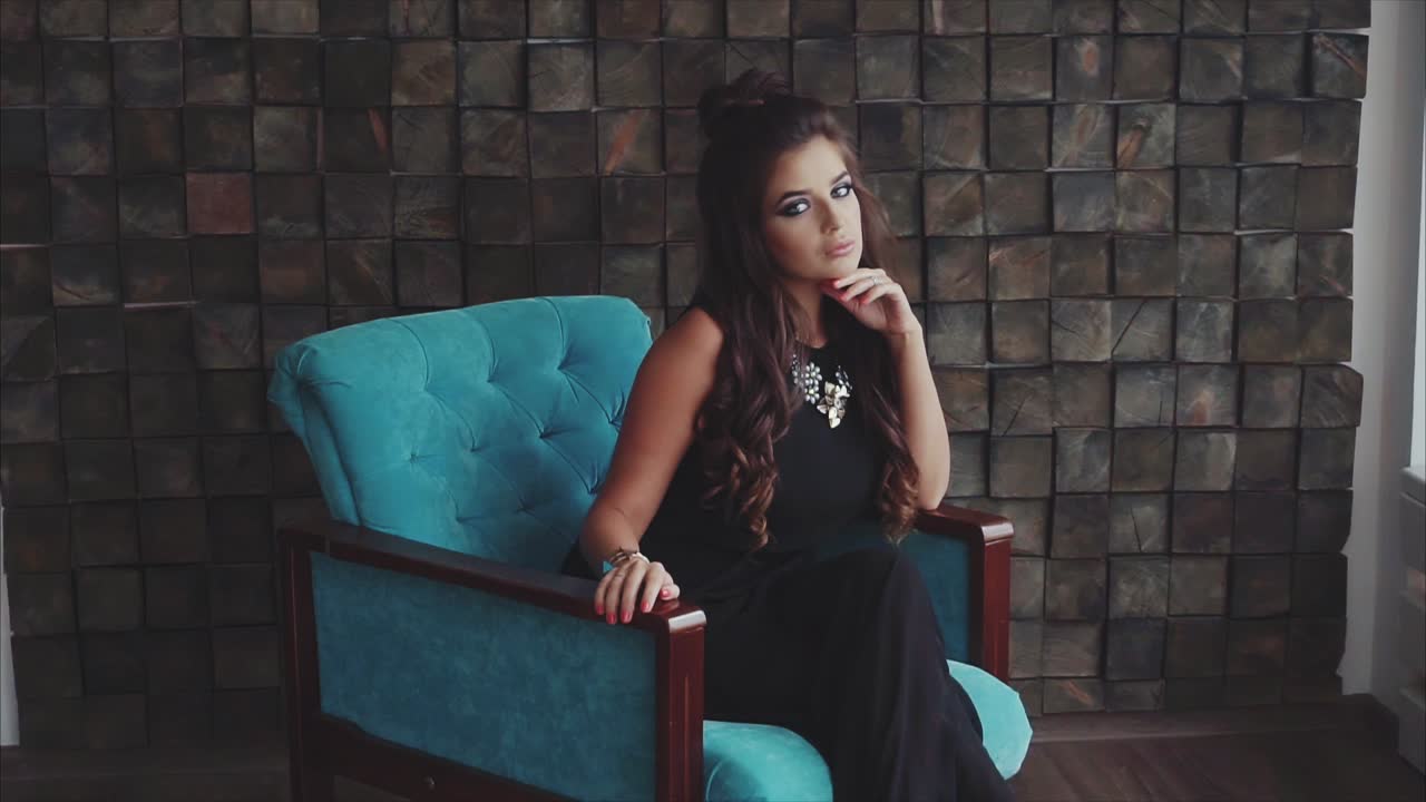 mujer con vestido negro y silla azul azul