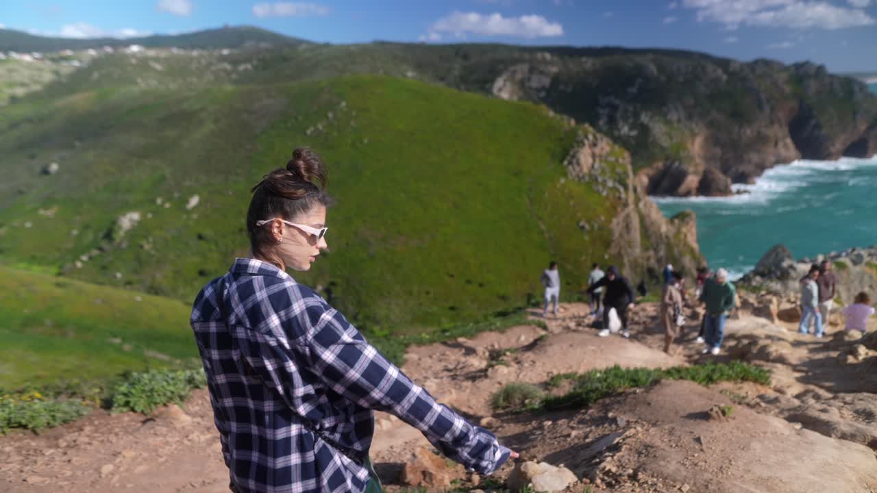 mujer caminando por un sendero de acantilado costero