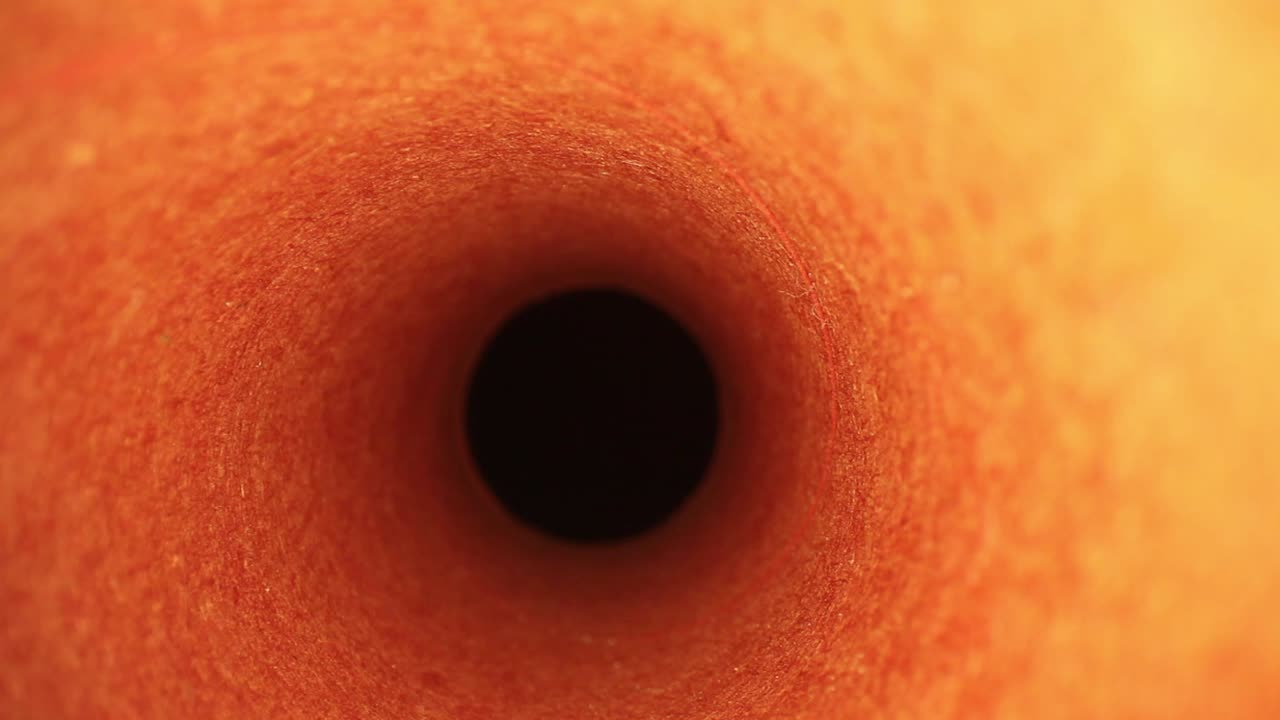 sacando lentamente de una cubierta de rodillo de pintura naranja, enfoque medio en los bordes