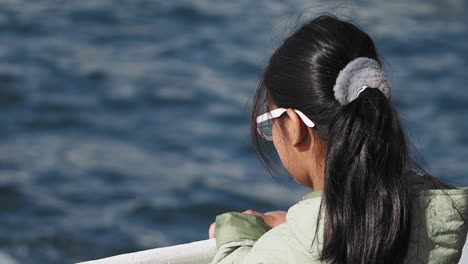 girl looking out at the ocean from a boat