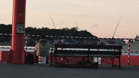 man sitting and fishing fish on bay