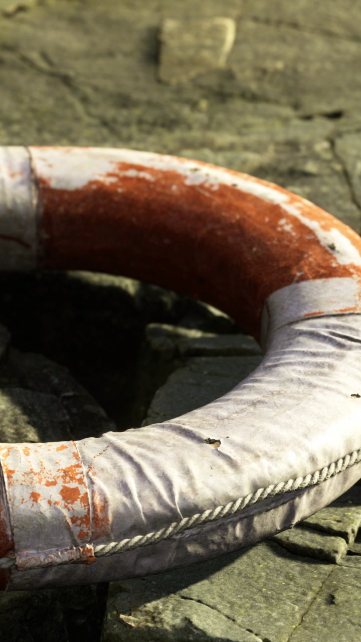 Lifebuoy rests on stone surface in outdoor setting during bright daylight