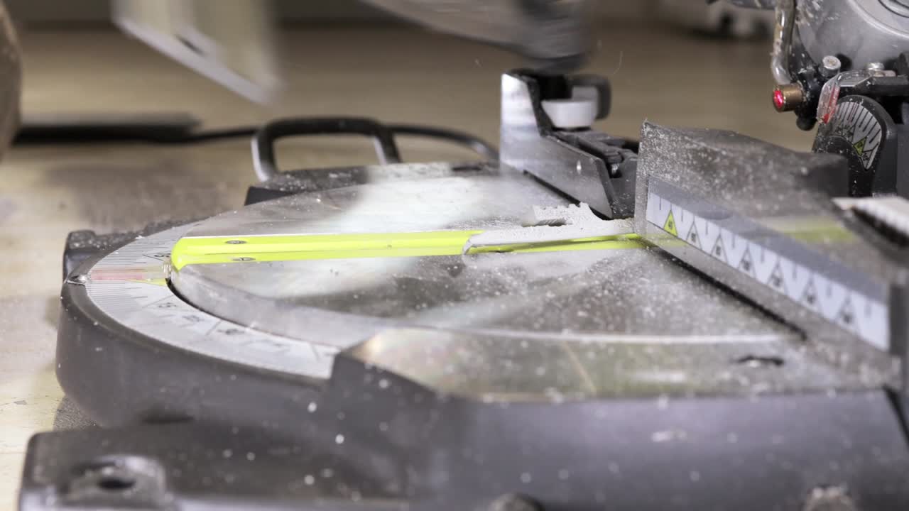 рабочий режет подставку на круговой пиле перед установкой.