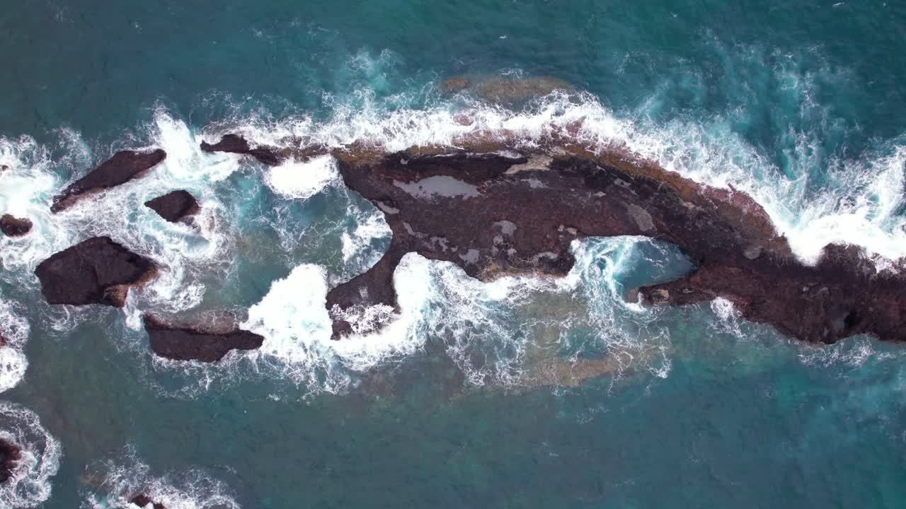 Stormy waves crash on Praia Piscina, São Tomé, a dramatic blend of wild ocean power and serene tropical beach landscape