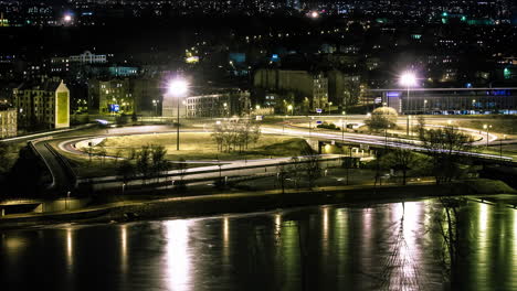 Lapso-De-Tiempo-De-La-Conducción-De-Tráfico-En-La-Ciudad-Por-La-Noche-Con-El-Reflejo-De-La-Luz-Del-Río