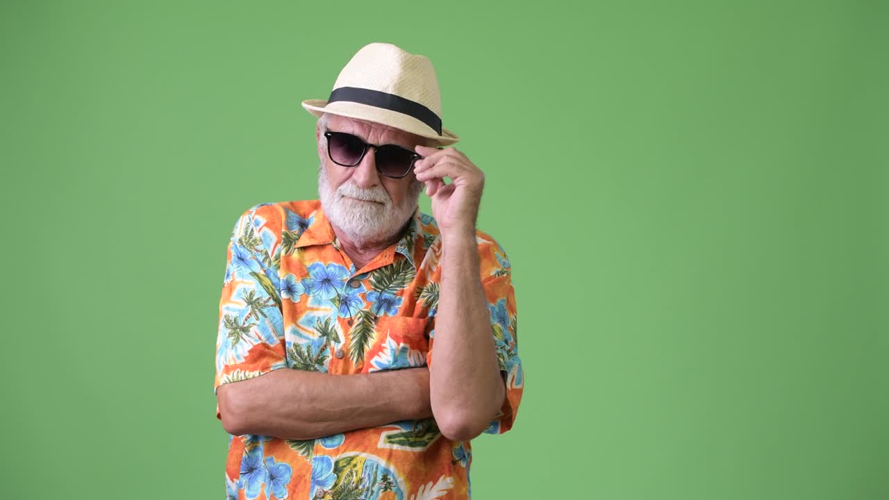 hombre turista barbudo y guapo listo para las vacaciones contra un fondo verde