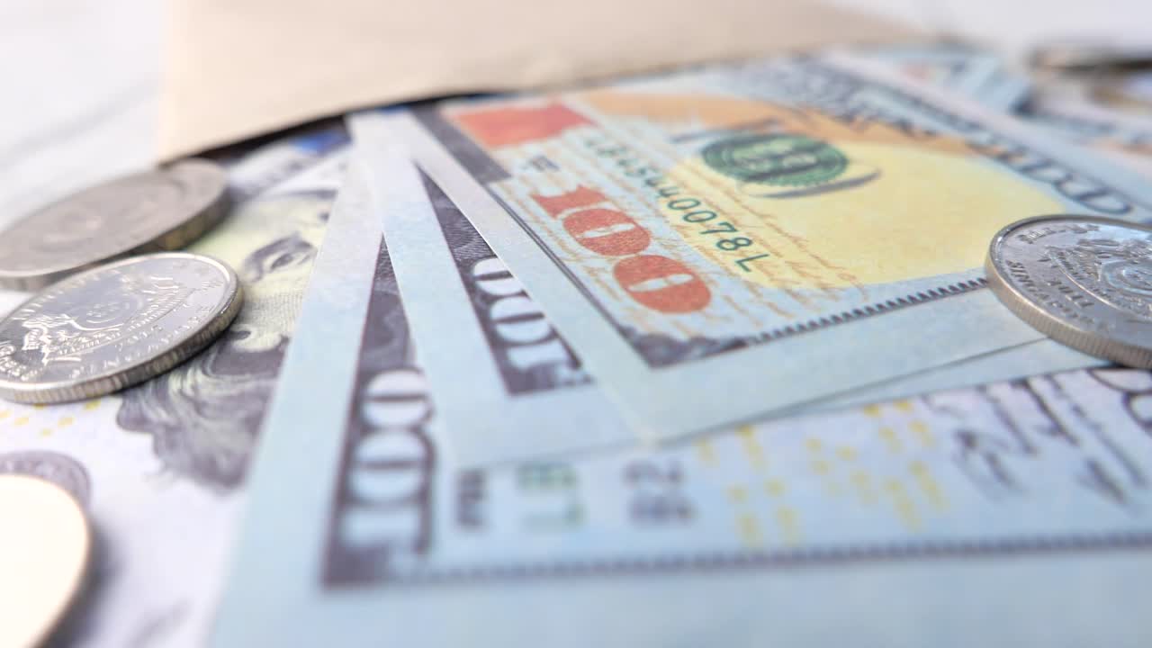 dólares y monedas en un sobre.