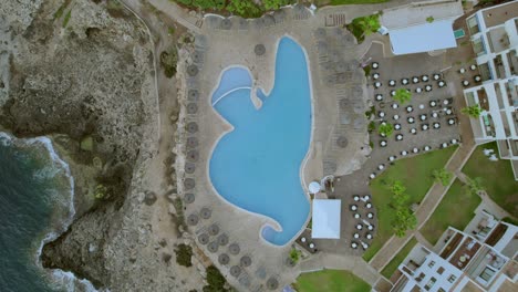 aerial from above view in slowmo footage of swimming pool luxury resort at palma de mallorca, spain in sunny day