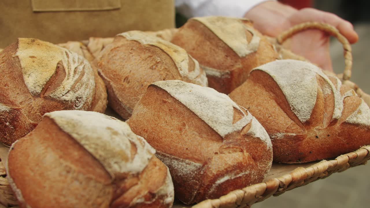 The baker holds in hands a of fresh bread close-up. Artisan bread is making by skill bakers using natural and high-quality ingredients. Food with health and flavour benefits.